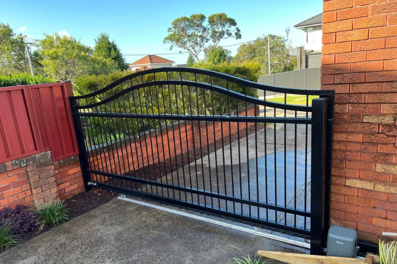Black automatic gates with sliding driveway mechanism installed by Muller's Fencing Sydney
