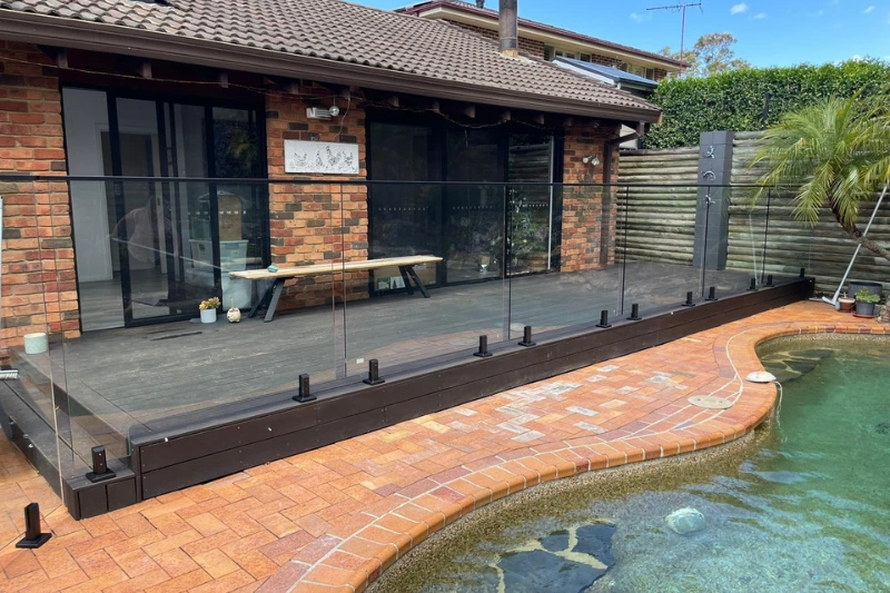 Frameless glass pool fencing installed on a modern timber deck — Muller's Fencing Sydney