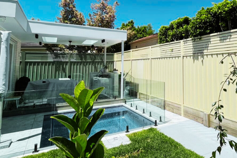 Cream Colorbond fencing installation on a home boundary line near a pool — Muller's Fencing Sydney